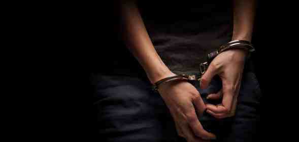 A teenager hands in handcuffs