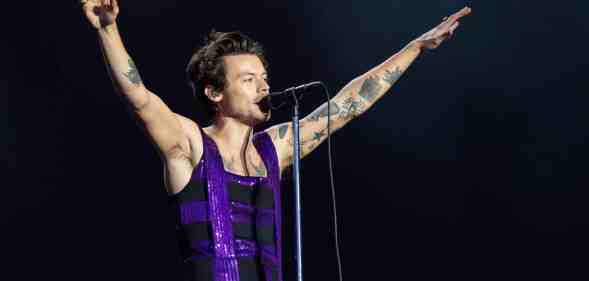 Harry Styles performs on the Main Stage at War Memorial Park in a purple sequinned dress