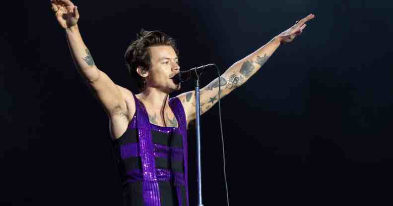 Harry Styles performs on the Main Stage at War Memorial Park in a purple sequinned dress