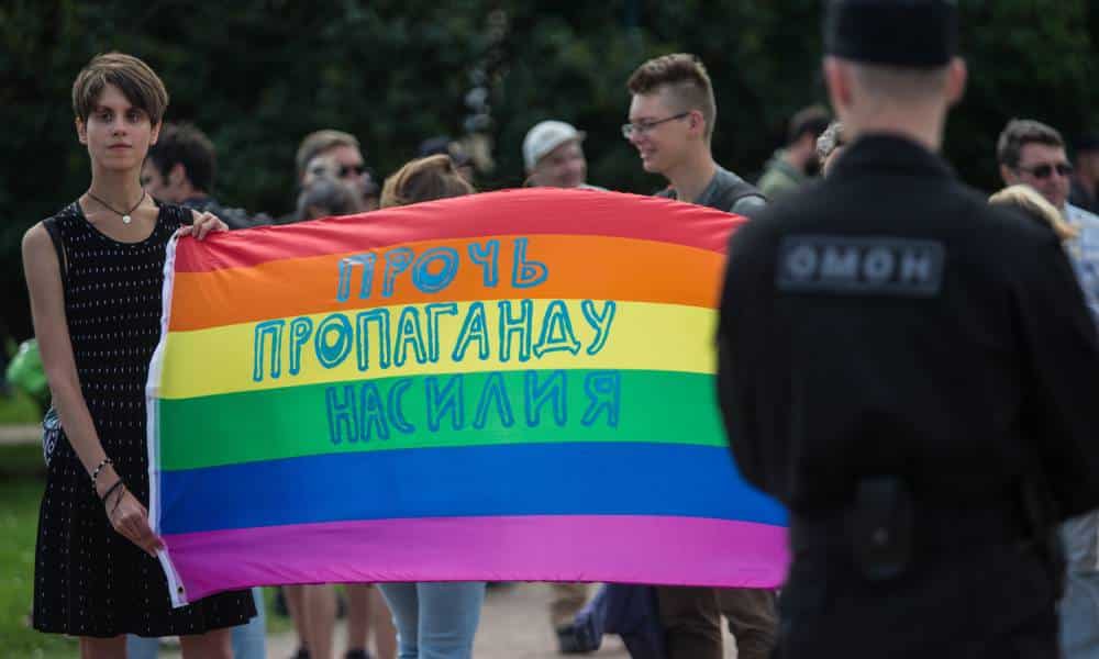 A participant holds a banner with the inscription 'Stop propaganda of violence' during an LGBTQ+ demonstration in St Petersburg's Field of Mars