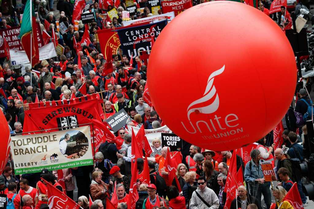 Protesters march with placards and trades union banners as part of a Trade Union Congress (TUC) demo