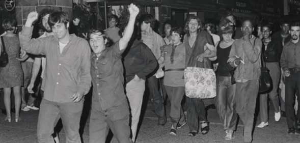 Mark at the Stonewall riots in 1969, pictured at the front with his arm raised.