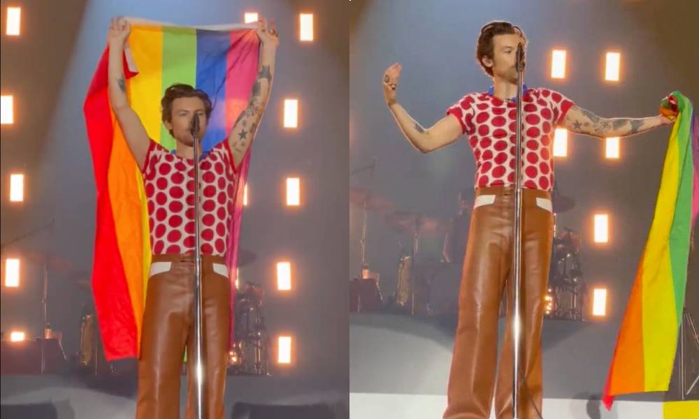 Harry Styles holds up an LGBTQ+ pride flag as he stands on stage during a concert in Oslo Norway