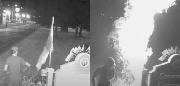 A man wearing a ball cap and t-shirt is seen in two black-and-white screenshots taken from trail camera footage setting a LGBTQ+ Pride flag, which was displayed next to a sign outside Lansing, Michigan, on fire