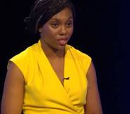 Kemi Badenoch wears a bright yellow outfit as she speaks at a podium during a Tory leadership election debate