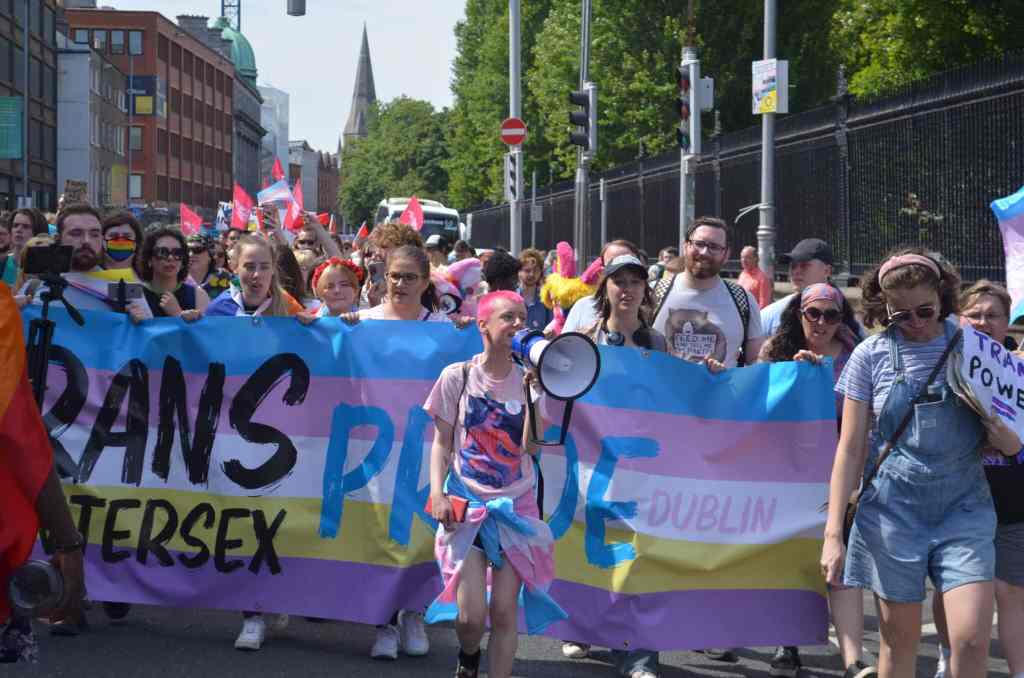 Trans and Intersex Pride co-founder Ollie Bell holds a megaphone in front of a banner during a Dublin Pride event