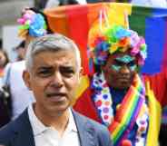 Sadiq Khan, behind him in a person holding a rainbow Pride flag