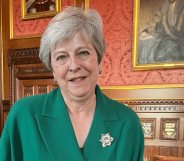 Theresa May in a House of Commons room lined with portraits