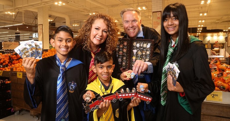 Coles customers hold packs of the collectable Harry Potter Magical Builders