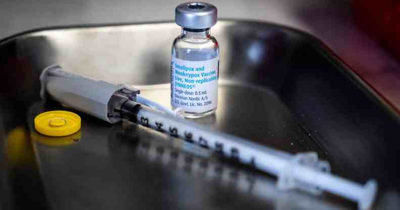 A bottle of monkeypox vaccine sits next to a needle on a tray