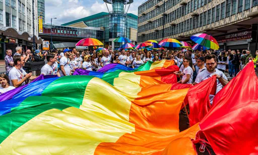 A Birmingham Pride procession goes through the city's gay village with LGBTQ+ flags