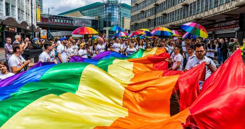 A Birmingham Pride procession goes through the city's gay village with LGBTQ+ flags