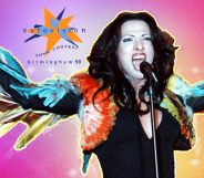 Dana International singing in front of the Eurovision 98 logo