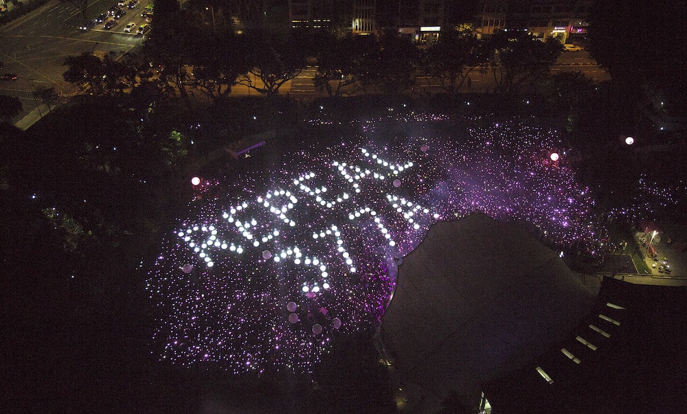 Attendees form the words 'Repeal 377A' in lights at Singapore's Pink Dot event, 2019