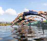Athetes dive during the mixed relay Triathlon competition at the 2020 Tokyo Olympic Games