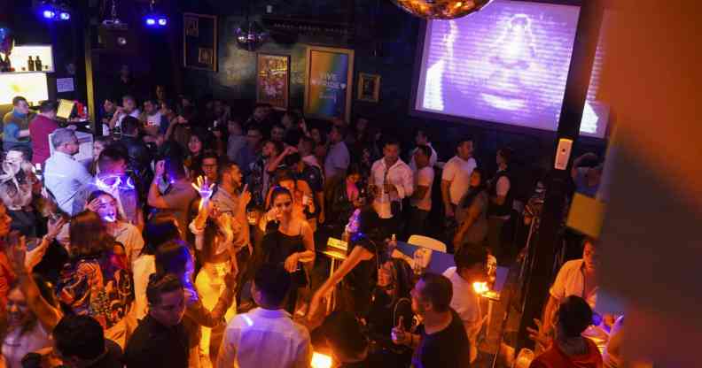 A huge crowd of people in a dimly lit nightclub.