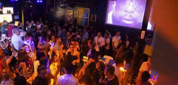 A huge crowd of people in a dimly lit nightclub.