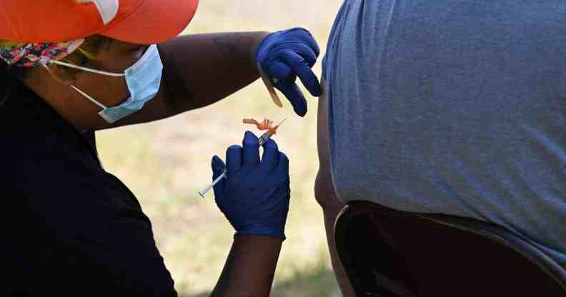 A public health worker wearing a face mask and surgical gloves administers the monkeypox vaccine at the Balboa Sports Center in the Encino neighborhood of Los Angeles, California, on July 27, 2022.