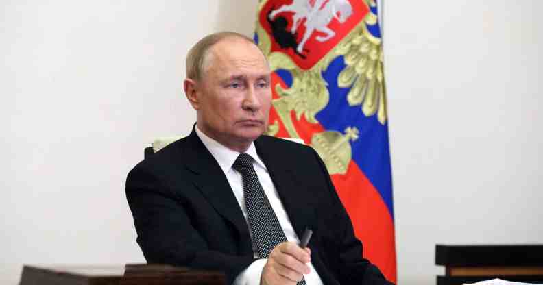 Vladimir Putin sits at a desk