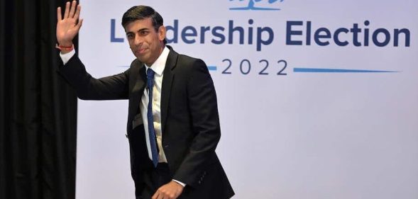 In this photograph, Rishi Sunak waves as he walks across the stage the the Conservative leadership hustings in Perth, Scotland