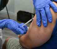 In this photograph, a nurse vaccinates a patient against monkeypox