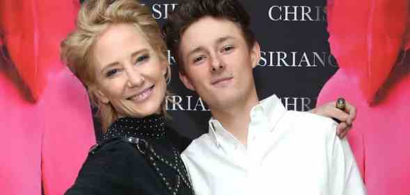 Anne Heche smiles while wearing a dark outfit as she stands next to her son Homer Laffoon who is wearing a white top