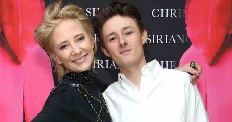 Anne Heche smiles while wearing a dark outfit as she stands next to her son Homer Laffoon who is wearing a white top