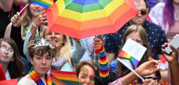 A woman holding a rainbow umbrella