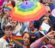 A woman holding a rainbow umbrella
