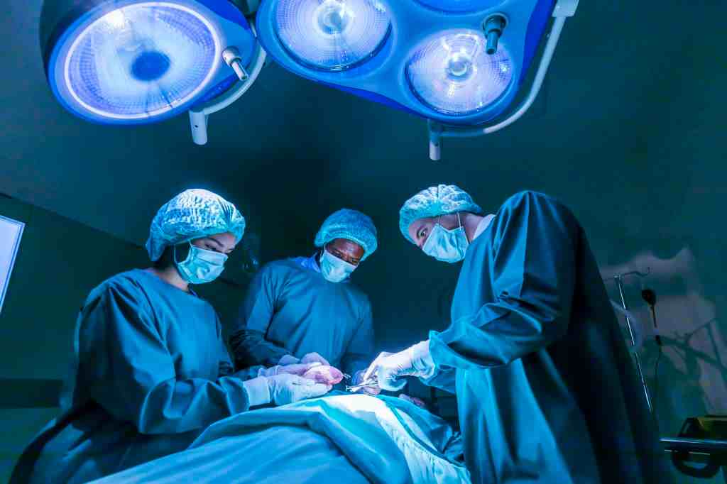 Team of surgeon doctors are performing heart surgery operation for patient