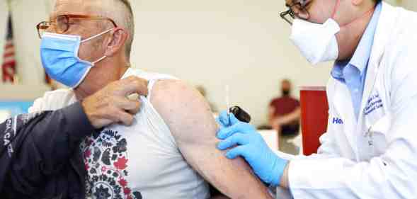 Someone administers a dose of the monkeypox vaccine to a person