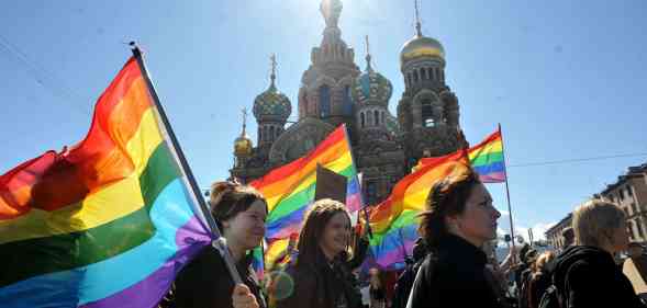 People holding rainbow flag in a group