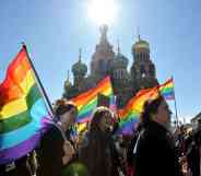 People holding rainbow flag in a group