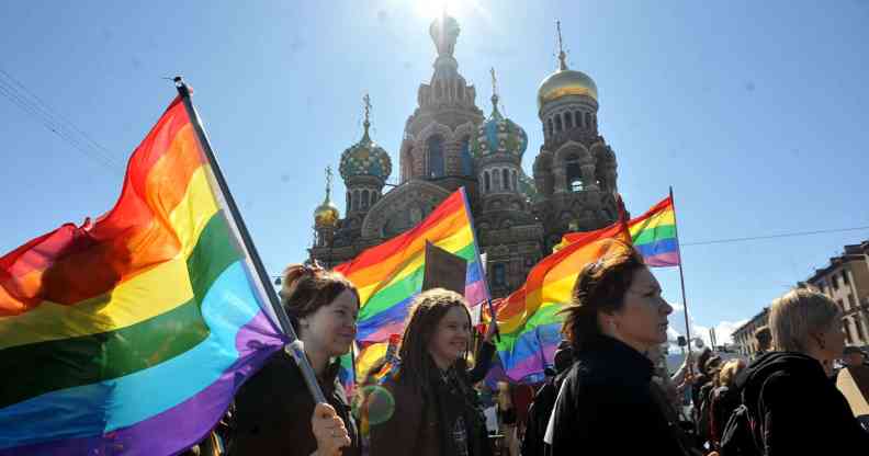 People holding rainbow flag in a group