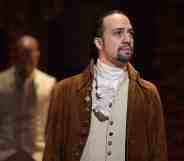 Lin Manuel Miranda, who plays Alexander Hamilton looks off into the distant wearing a brown jacket and cream waistcoat.