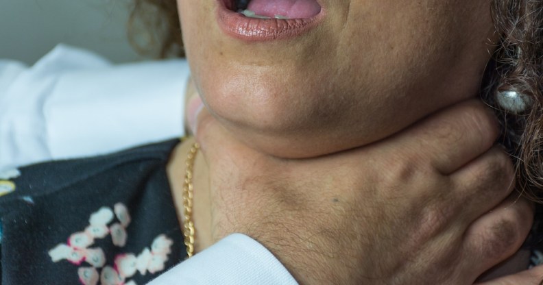 A stock photo of a woman with hands around her throat