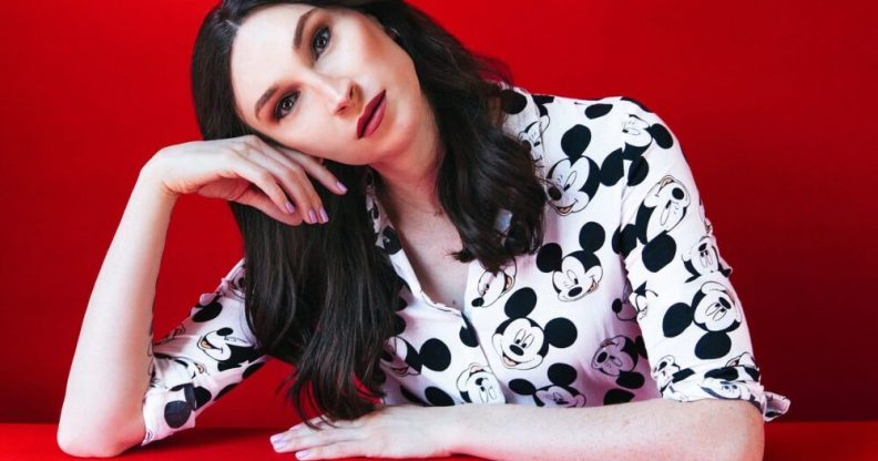 Juno Dawson tilting her head with a red background.