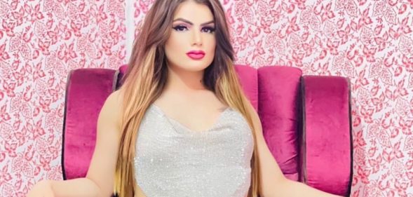 Trans woman Ozlam pictured sitting in a pink chair.