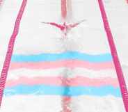 A photo of a swimmer in a lane, with the trans flag superimposed