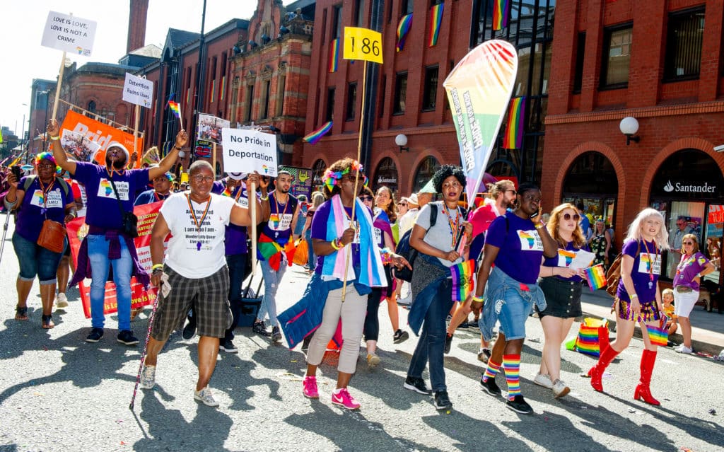 A scene from 2019 Manchester Pride event showing people marching on the streets