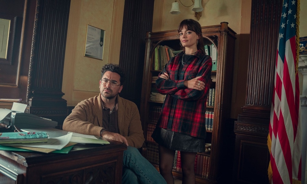 In this photograph, Dan Levy (L) and Emma Mackey stand by one another on the set of Sex Education