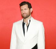 Promotional still of comedian Billy Eichner wearing a black shirt and white suit jacket.