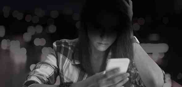 Woman sat looking down at her phone