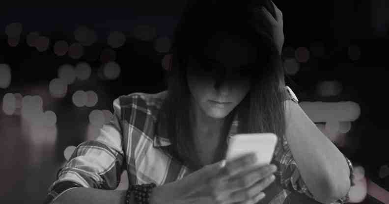 Woman sat looking down at her phone