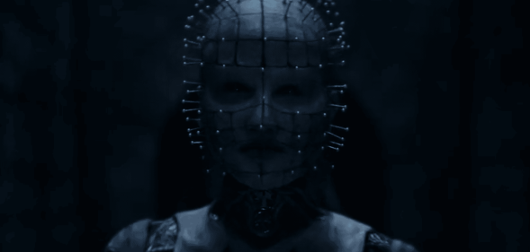 Jamie Clayton dressed in prosthetic makeup and pins dotted around her face.