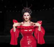 Drag Race UK star Cherry Valentine wearing a red dress against a black background in an edited image.