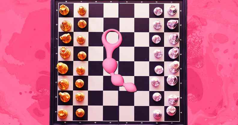 An image of a chess board against a pink background with anal beads in the centre of the board.