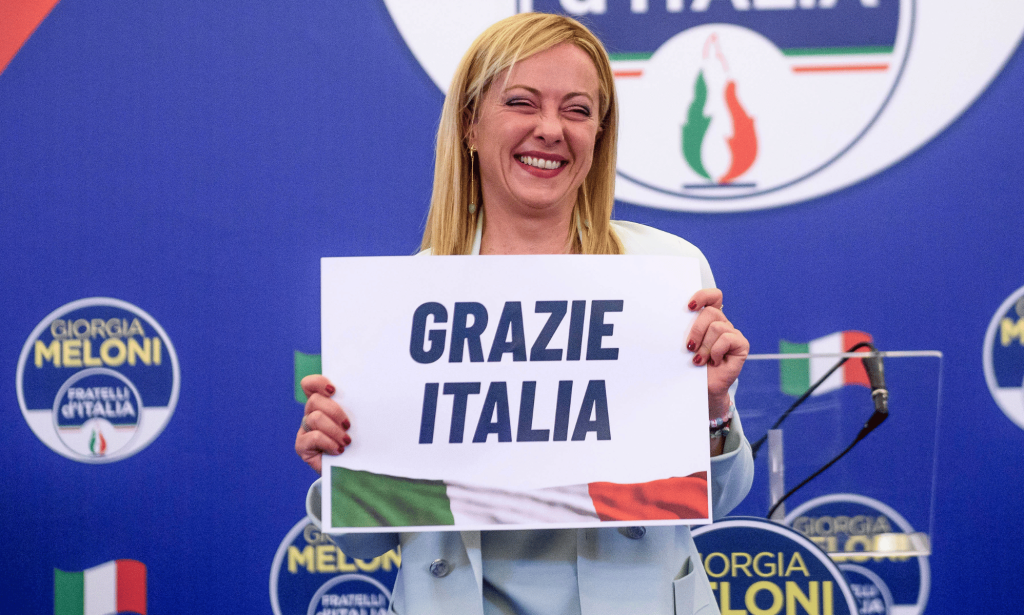 Giorgia Meloni holds up a sign reading 'Grazie Italia'