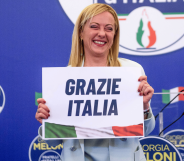 Giorgia Meloni holds up a sign reading 'Grazie Italia'