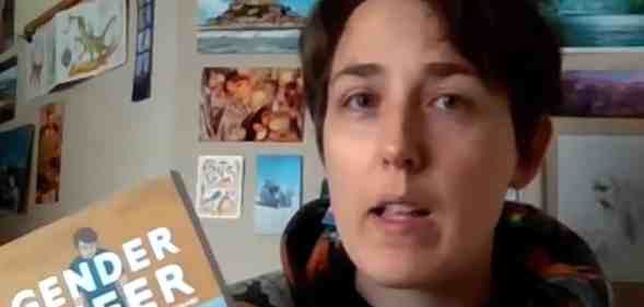 Maia Kobabe holds up a copy eir graphic memoir Gender Queer during an interview